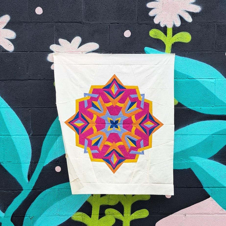 Nesting Phoenix star foundation paper pieced pattern hanging on a graffiti wall. 